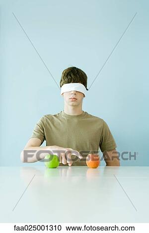 Young male wearing blindfold, pointing to one of two apples View Large Photo Image Stock Image - Young male wearing blindfold, pointing to one of two apples. Fotosearch