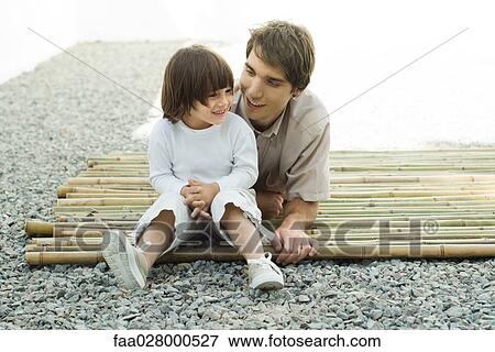 Young man and son relaxing together View Large Photo Image Stock Photo - Young man and son relaxing together. Fotosearch