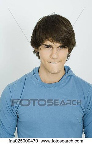 Young man biting lip, looking at camera View Large Photo Image Stock Image - Young man biting lip, looking at camera. Fotosearch