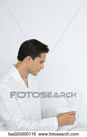 Young man dressed in white holding teddy bear, side view View Large Photo Image Stock Photograph - Young man dressed in white holding teddy bear, side view. Fotosearch