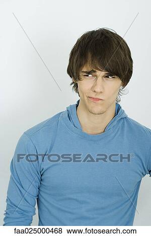 Young man furrowing brow, looking away View Large Photo Image Stock Photo - Young man furrowing brow, looking away. Fotosearch