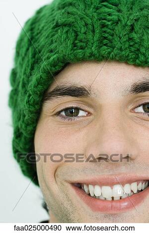 Young man in knit hat smiling at camera, cropped view View Large Photo Image Stock Image - Young man in knit hat smiling at camera, cropped view. Fotosearch