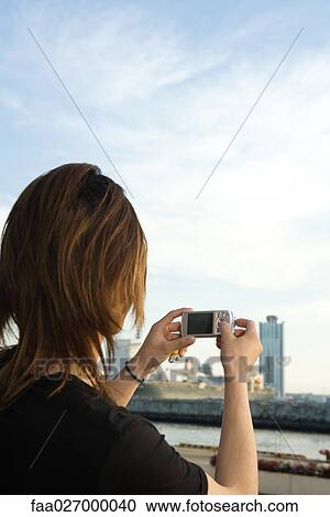 Young man photographing cityscape with digital camera, rear view View Large Photo Image Stock Image - Young man photographing cityscape with digital camera, rear view. Fotosearch