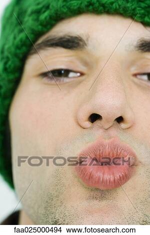 Young man puckering lips, looking at camera, cropped view View Large Photo Image Picture - Young man puckering lips, looking at camera, cropped view. Fotosearch