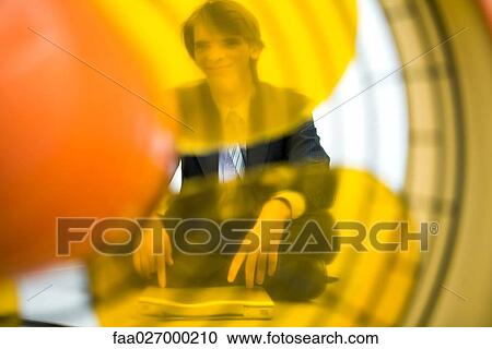 Young man sitting with laptop computer, looking at camera, viewed through electric fan View Large Photo Image Stock Image - Young man sitting with laptop computer, looking at camera, viewed through electric fan. Fotosearch