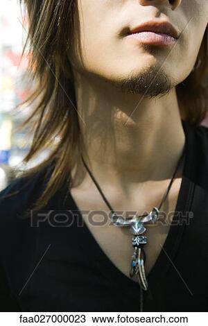 Young man wearing necklace with large pendant, close-up, cropped view View Large Photo Image Stock Image - Young man wearing necklace with large pendant, close-up, cropped view. Fotosearch
