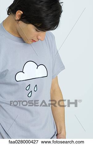 Young man wearing tee-shirt printed with cloud and raindrops, head down View Large Photo Image Stock Photo - Young man wearing tee-shirt printed with cloud and raindrops, head down. Fotosearch