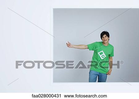Young man wearing tee-shirt with MP3 graphic, listening to MP3 player View Large Photo Image Stock Image - Young man wearing tee-shirt with MP3 graphic, listening to MP3 player. Fotosearch