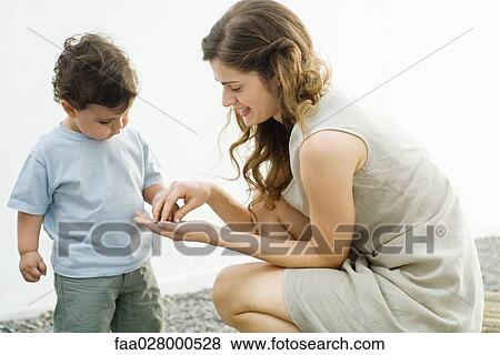 Young mother with curious toddler View Large Photo Image Stock Photo - Young mother with curious toddler. Fotosearch