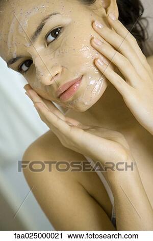 Young woman applying facial mask, looking at camera, cropped view View Large Photo Image Stock Image - Young woman applying facial mask, looking at camera, cropped view. Fotosearch