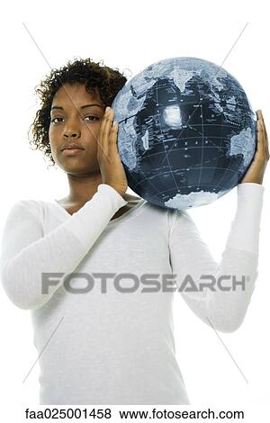 Stock Photo - Young woman carrying globe on shoulder, looking at camera. Fotosearch