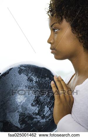Young woman holding globe, looking away, profile View Large Photo Image Stock Image - Young woman holding globe, looking away, profile. Fotosearch