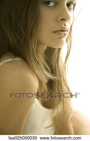 Young woman in tank top looking over shoulder at camera, cropped view View Large Photo Image Stock Photography - Young woman in tank top looking over shoulder at camera, cropped view. Fotosearch