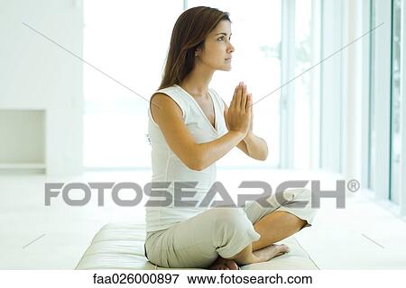 Young woman sitting in lotus position, looking away View Large Photo Image Stock Photo - Young woman sitting in lotus position, looking away. Fotosearch