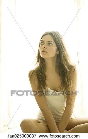 Young woman sitting in underwear, looking up View Large Photo Image Stock Photo - Young woman sitting in underwear, looking up. Fotosearch