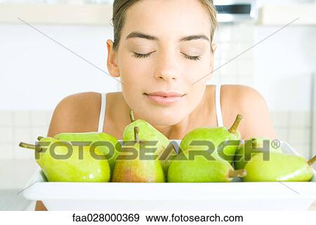 Young woman smelling fresh pears, eyes closed, close-up View Large Photo Image Stock Photo - Young woman smelling fresh pears, eyes closed, close-up. Fotosearch