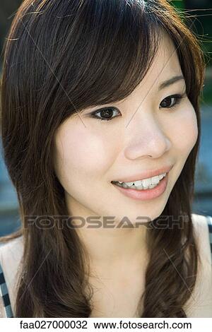 Young woman smiling, looking away, portrait View Large Photo Image Stock Image - Young woman smiling, looking away, portrait. Fotosearch