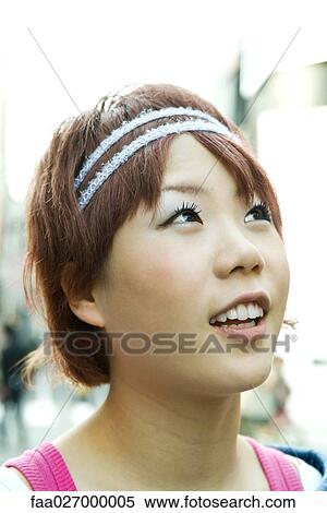 Young woman smiling, looking up, portrait View Large Photo Image Stock Photography - Young woman smiling, looking up, portrait. Fotosearch