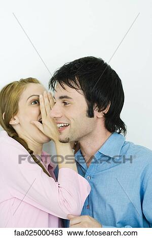 Young woman whispering in man's ear, close-up View Large Photo Image Stock Image - Young woman whispering in man's ear, close-up. Fotosearch