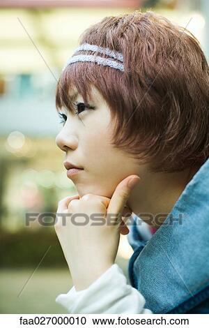 Young woman with chin resting on hands, looking away, profile View Large Photo Image Stock Image - Young woman with chin resting on hands, looking away, profile. Fotosearch