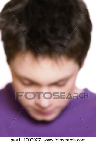 Stock Photo - Teenage boy bending head forward, close-up, blurred. Fotosearch