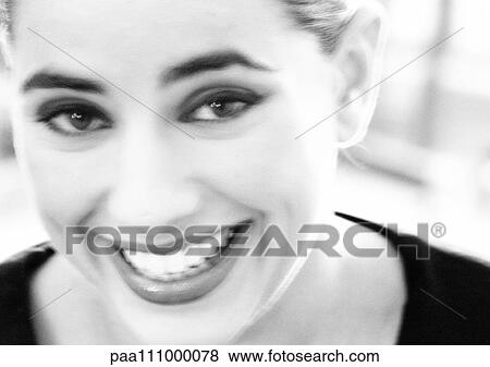 Stock Photo - Woman smiling, close-up, blurred, b&w. Fotosearch