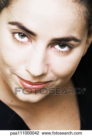 Stock Image - Woman smiling, high angle view, close-up, portrait. Fotosearch