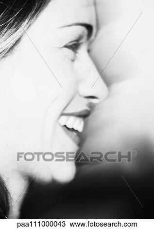Stock Image - Woman smiling, side view, b&w. Fotosearch