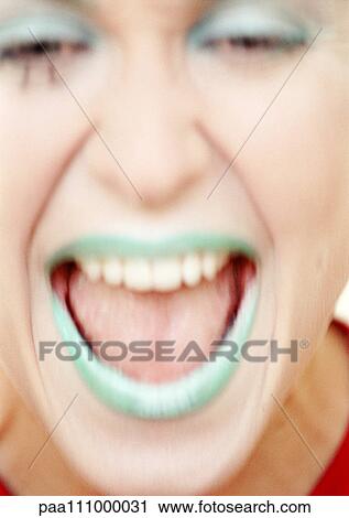 Stock Image - Woman with green lipstick laughing, close-up. Fotosearch