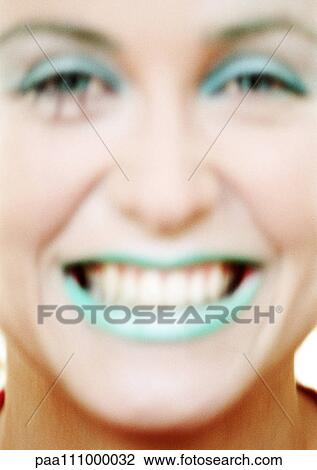 Stock Image - Woman with green lipstick smiling, close-up. Fotosearch