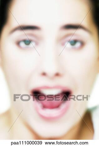 Stock Photo - Woman's face, mouth open, close-up, blurred. Fotosearch
