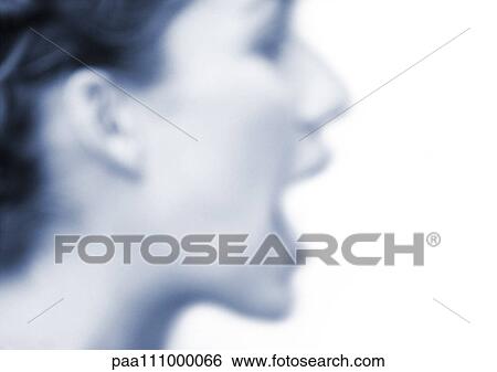 Stock Photograph - Woman's face with mouth open, side view, blurred, blue tone. Fotosearch