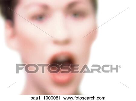 Stock Image - Woman's face with open mouth, close-up, blurred. Fotosearch