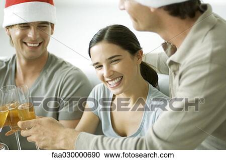 Adult friends clinking champagne glasses, smiling, focus on woman in center View Large Photo Image Stock Image - Adult friends clinking champagne glasses, smiling, focus on woman in center. Fotosearch