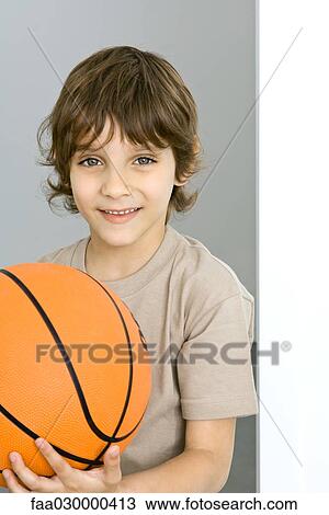 Boy holding basketball, portrait View Large Photo Image Stock Image - Boy holding basketball, portrait. Fotosearch