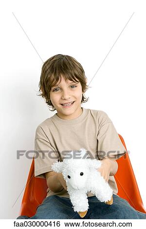 Boy holding plush toy lamb View Large Photo Image Stock Photograph - Boy holding plush toy lamb. Fotosearch