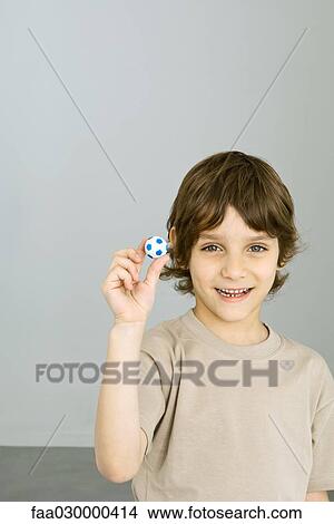 Boy holding up tiny soccer ball View Large Photo Image Picture - Boy holding up tiny soccer ball. Fotosearch