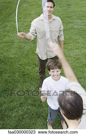 Boy playing jump rope with two men, smiling, cropped view View Large Photo Image Stock Image - Boy playing jump rope with two men, smiling, cropped view. Fotosearch