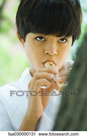 Stock Image - Boy playing recorder, close-up. Fotosearch
