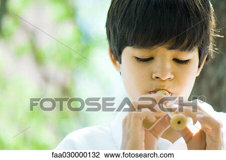 Stock Image - Boy playing recorder. Fotosearch