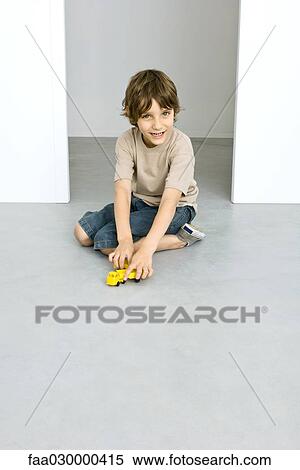 Stock Photography - Boy playing with toy trucks. Fotosearch