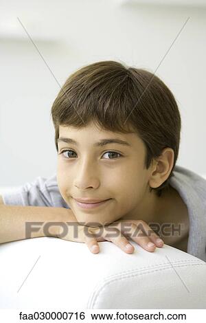 Boy resting head on chin, smiling at camera, portrait View Large Photo Image Stock Photograph - Boy resting head on chin, smiling at camera, portrait. Fotosearch