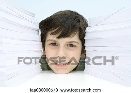 Boy smiling at camera between stacks of paper, portrait View Large Photo Image Stock Image - Boy smiling at camera between stacks of paper, portrait. Fotosearch