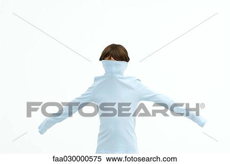 Stock Photography - Boy wearing turtleneck pulled over his face, arms outstretched. Fotosearch