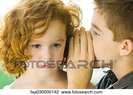 Boy whispering into girl's ear, close-up View Large Photo Image Stock Image - Boy whispering into girl's ear, close-up. Fotosearch