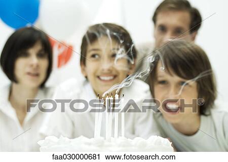 Boys blowing out candles on birthday cake, parents in background View Large Photo Image Stock Image - Boys blowing out candles on birthday cake, parents in background. Fotosearch