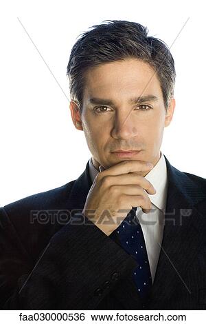 Businessman with hand under chin, looking at the camera, portrait View Large Photo Image Stock Photograph - Businessman with hand under chin, looking at the camera, portrait. Fotosearch