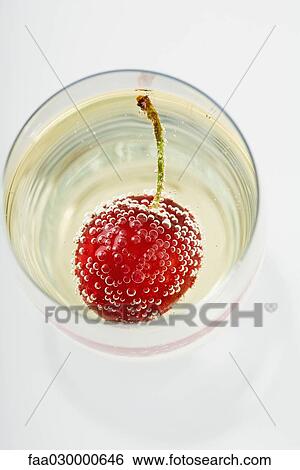 Cherry and bubbles in champagne glass, high angle view View Large Photo Image Stock Photograph - Cherry and bubbles in champagne glass, high angle view. Fotosearch