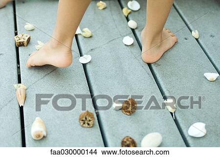 Child standing among seashells, cropped view of feet View Large Photo Image Picture - Child standing among seashells, cropped view of feet. Fotosearch