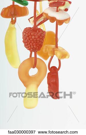 Stock Photo - Colorful candy hanging on strings, close-up. Fotosearch